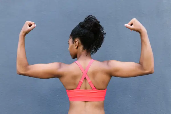 Musculação em casa com halteres e colchonete, realizando exercícios simples e eficazes para iniciantes. Ambiente organizado e acolhedor, mostrando como começar a treinar musculação em casa